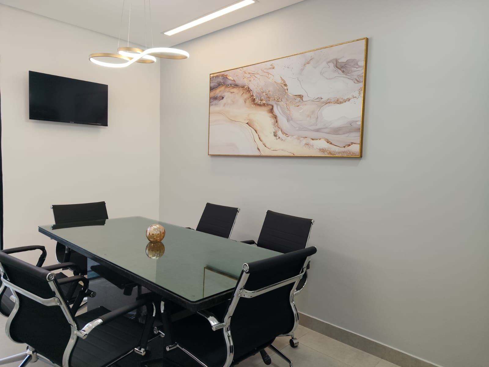 Sala de reuniões do escritório com mesa ampla e cadeiras ao redor
